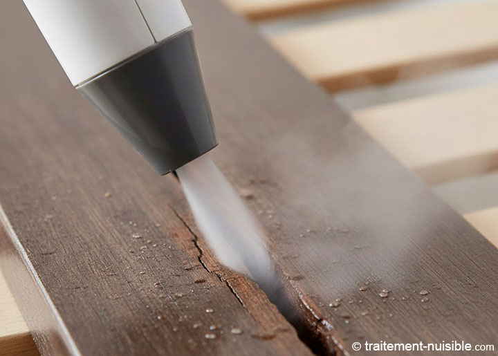 Application minutieuse de la vapeur sèche sur les lattes du lit